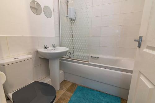 a bathroom with a sink and a toilet and a bath tub at Luxury stay in EastwoodTown centre in Eastwood