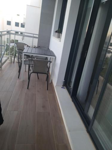 balcón con mesa, sillas y ventana en Apartamento Almijara, en Torre del Mar