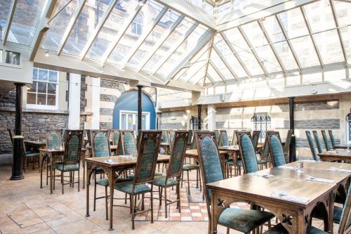 a dining room with wooden tables and chairs at Arnos Manor Hotel in Bristol