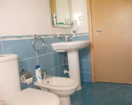 a bathroom with a white toilet and a sink at Ionian Breeze Apartments Borsh in Borsh