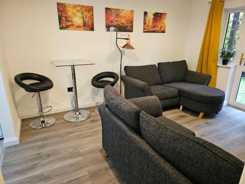 a living room with a couch and a chair at 1 bed modern flat in Didcot