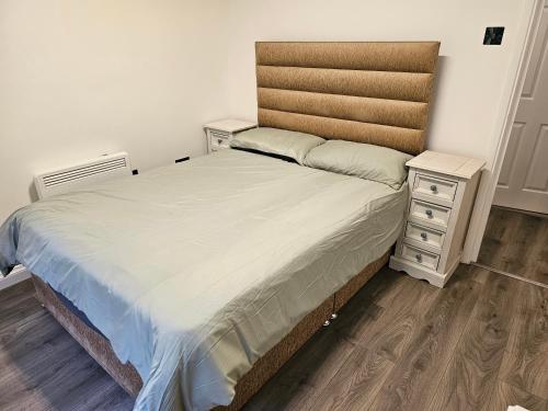 a bedroom with a bed and a night stand at 1 bed modern flat in Didcot