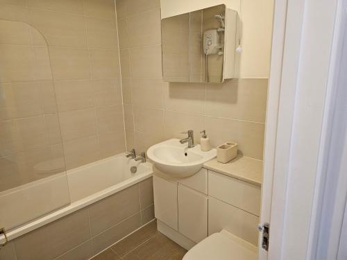 a bathroom with a sink and a toilet and a tub at 1 bed modern flat in Didcot