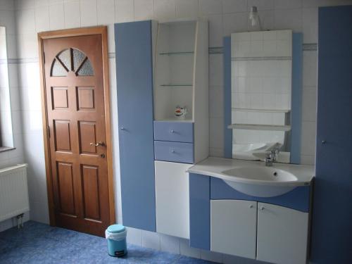 a blue and white bathroom with a sink and a door at appartement Courcelles in Courcelles