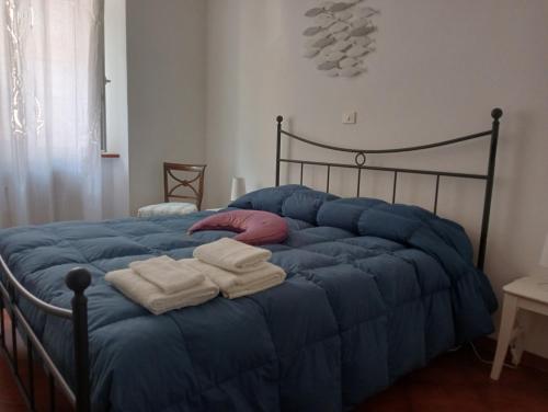 a blue bed with towels on top of it at Casa Azzurra in Orbetello