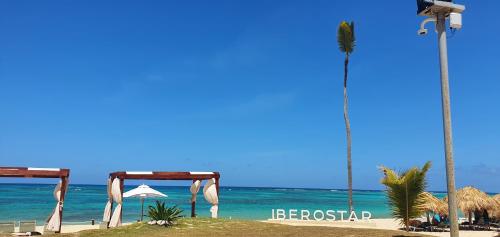 a beach with a tent and a palm tree and the ocean at Luxury Villa Iberosta - 4BDR, Private Beach, Pool & Jacuzzi in Punta Cana
