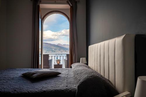 a bedroom with a bed and a large window at Hotel Romagna in Baveno