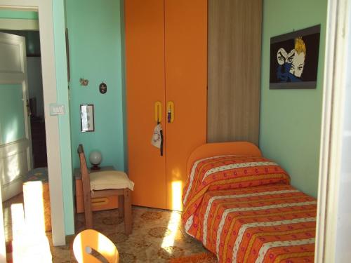ジャルディーニ・ナクソスにあるMare e Montiのベッドルーム(オレンジ色のベッド1台、椅子付)