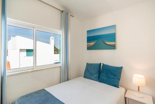 a bedroom with a bed and a window at L&A Villa with Private heated Pool in Prainha in Alvor