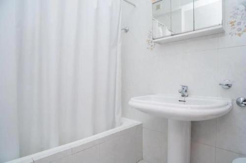 y baño blanco con lavabo y ducha. en Holidays in Algarve!, en Portimão