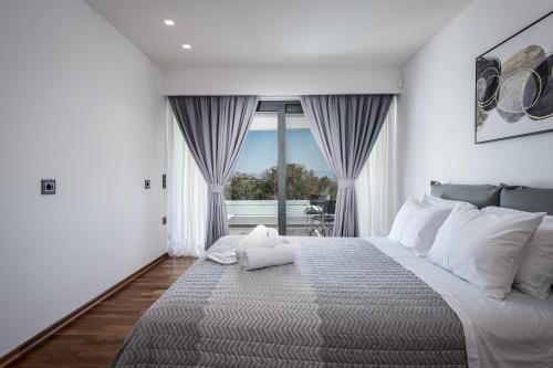 ein Schlafzimmer mit einem großen Bett und einem großen Fenster in der Unterkunft Villa Nova Kos island in Kos-Stadt