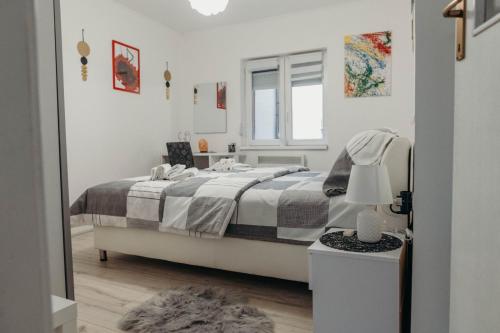 een witte slaapkamer met een bed en een spiegel bij HOLY in Ðakovo