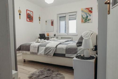 a white bedroom with a bed and a mirror at HOLY in Ðakovo