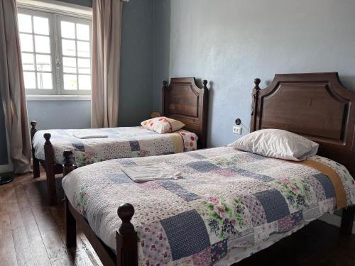 1 dormitorio con 2 camas y ventana en Fernando Guest House, en Aveiro