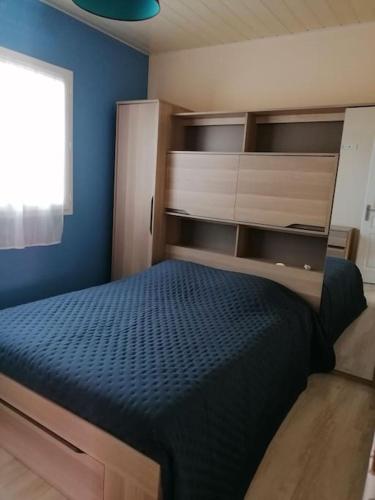 une chambre avec un lit et un mur bleu dans l'établissement maison entre lacs et ocean, à Aureilhan