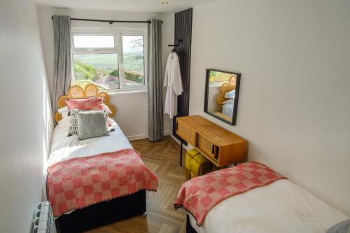 Habitación pequeña con 2 camas y ventana en Priory Bay Escapes - Matahari, en Tenby