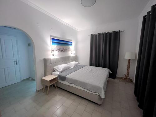 a bedroom with a bed and a table and a lamp at ATHANASIA APARTMENTS in Skiathos Town