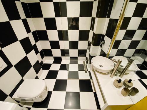 a bathroom with a black and white checkered floor at PROMO Elegant Apartments NEW - Colorful by the sea in Durrës