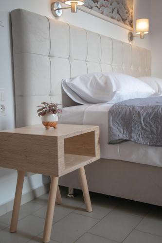 a bed with a table next to a bed with a white bed at ATHANASIA APARTMENTS in Skiathos Town