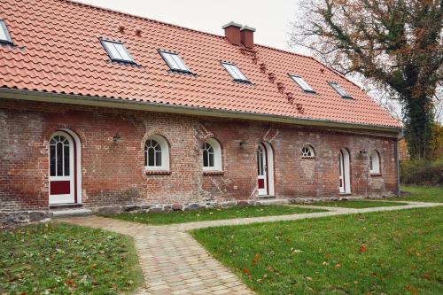 a red brick building with a red roof at Tränke in Barkelsby