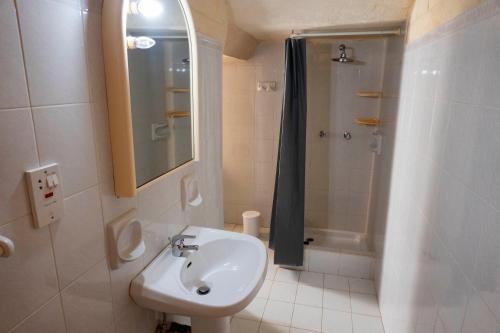 uma casa de banho com um lavatório e um chuveiro em VillaNirvana em Qala