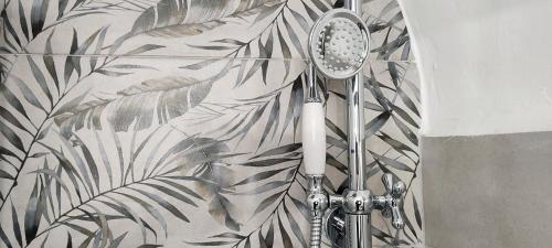 La salle de bains est pourvue d'une douche et d'un papier peint végétal. dans l'établissement Appartamento storico in zona Barberini, à Rome