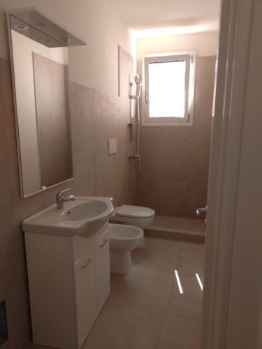 a bathroom with a sink and a toilet and a window at Salento nel Cuore in Capilungo