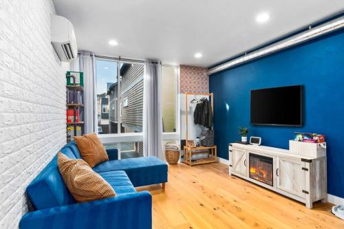 a blue living room with a blue wall and a tv at Modern Sustainable Design in Ballard - 92 Wlkscore in Seattle