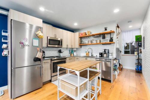 a kitchen with a stainless steel refrigerator and a wooden table at Modern Sustainable Design in Ballard - 92 Wlkscore in Seattle