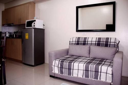 een woonkamer met een stoel en een televisie bij DRAMATIC SUNSET VIEW 1BR front CCP near NAIA in Manilla