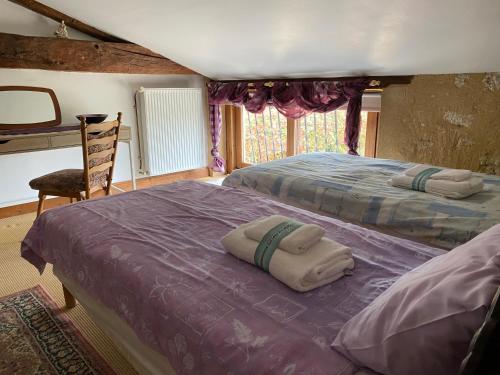 une chambre avec deux lits et une chaise dans l'établissement Gîte 3 étoiles avec piscine Dordogne, à Minzac