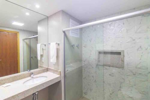 a bathroom with a glass shower and a sink at GARVEY FLAT in Brasilia