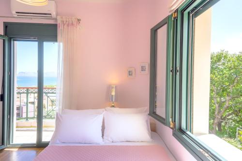 a bedroom with a bed and a large window at Deja Blue Chania in Daratso