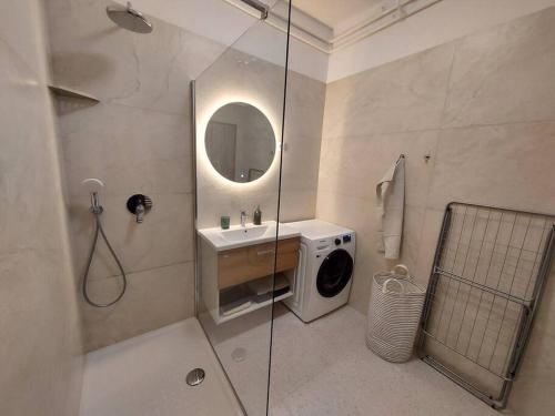a bathroom with a washing machine and a sink at Apartment Bezigrad in Ljubljana