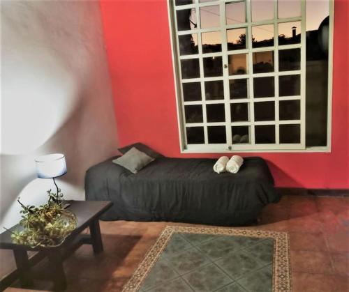 a living room with a black couch and a red wall at Quiet luxury loft in Mendoza