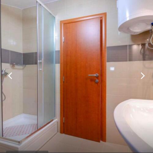 a bathroom with a shower and a wooden door at Crikvenica Villa Vanja in Kostelj