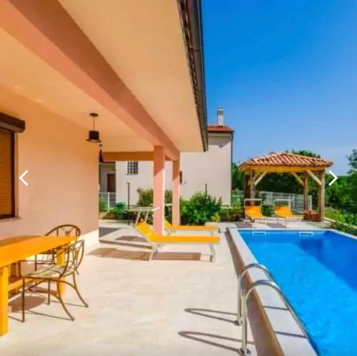 a patio with a pool and a gazebo at Crikvenica Villa Vanja in Kostelj