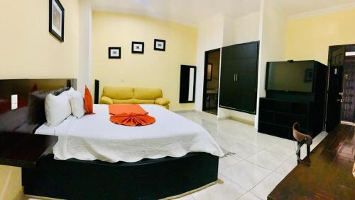een slaapkamer met een groot bed en een televisie bij Hotel Boutique Rosa de Lima in Querétaro