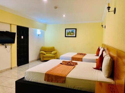 Cette chambre comprend deux lits et une télévision. dans l'établissement Hotel Boutique Rosa de Lima, à Querétaro