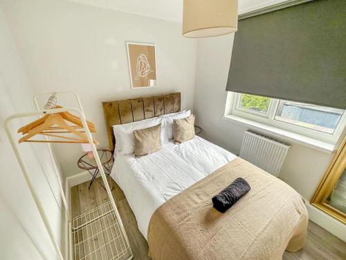 Schlafzimmer mit einem Bett mit schwarzer Fernbedienung in der Unterkunft New Cosy Luxury 3 Bedroom House in Battersea London in London