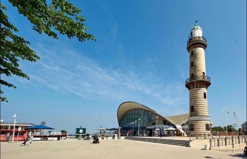 a building with a lighthouse in front of a building at Birnbom Warnemünde in Warnemünde