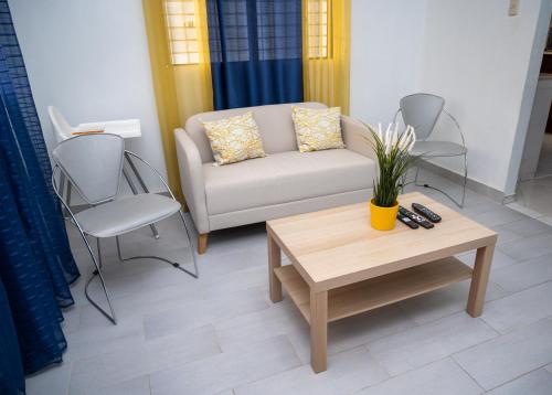 a living room with a couch and a table and chairs at Moderno Apartamento amueblado Full 3 habitaciones, wifi, Netflix in Santiago de los Caballeros