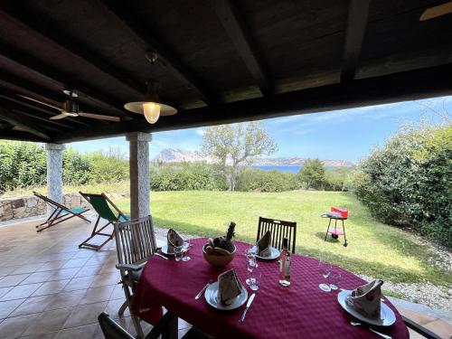 a table with a purple table cloth on a patio at CAPO CODA CAVALLO VILLA SALINEDDA GIARDINO VISTA MARE in Capo Coda Cavallo