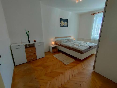 1 dormitorio con 1 cama y suelo de madera en 2-iz. byt v tichej lokalite s bezplatným parkovaním, en Liptovský Hrádok