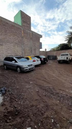 a group of cars parked next to a brick building at Complejo Don Tito in San Juan