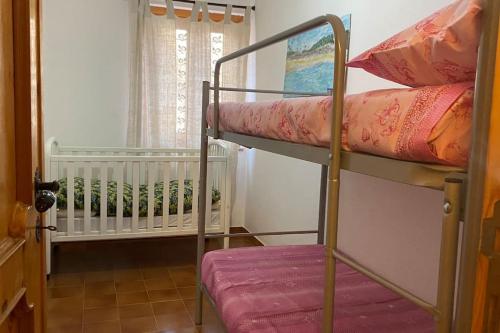 騰匹歐保沙尼亞的住宿－Flat Tempio Pausania near Costa Smeralda，一间卧室配有两张双层床和一张婴儿床。