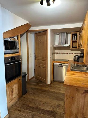 une cuisine avec un évier et une cuisinière four supérieur dans l'établissement Chalet Petite Etoile Des Neiges, à L'Alpe-d'Huez