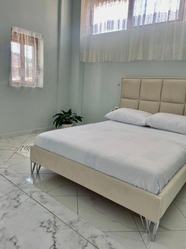 a bedroom with a large bed in a room at GUGA Host House in Sarandë