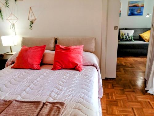 een slaapkamer met een bed met rode kussens erop bij Macallé in Siracusa