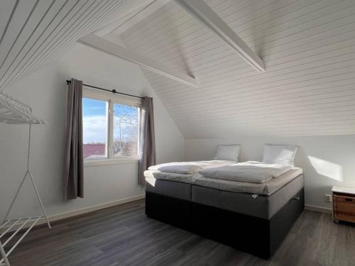 una camera con un letto in una stanza con una finestra di Lantlig villa i Ljungbyhed a Ljungbyhed